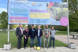 Carsten Möller, Fachbereichsleiter Bildung, Jugend und Kultur, Chris Kodritsch, stellvertretender Badleiter, Sascha Holtzmann, Badleiter, Bürger-meister Thomas Beckmann, Uwe Scharpenberg, Fachbereichsleiter Tiefbau-ten, und Luca Moriconi, stellvertretender Fraktionsvorsitzender Bündnis 90/Die Grünen vor dem neuen Freibad-Banner